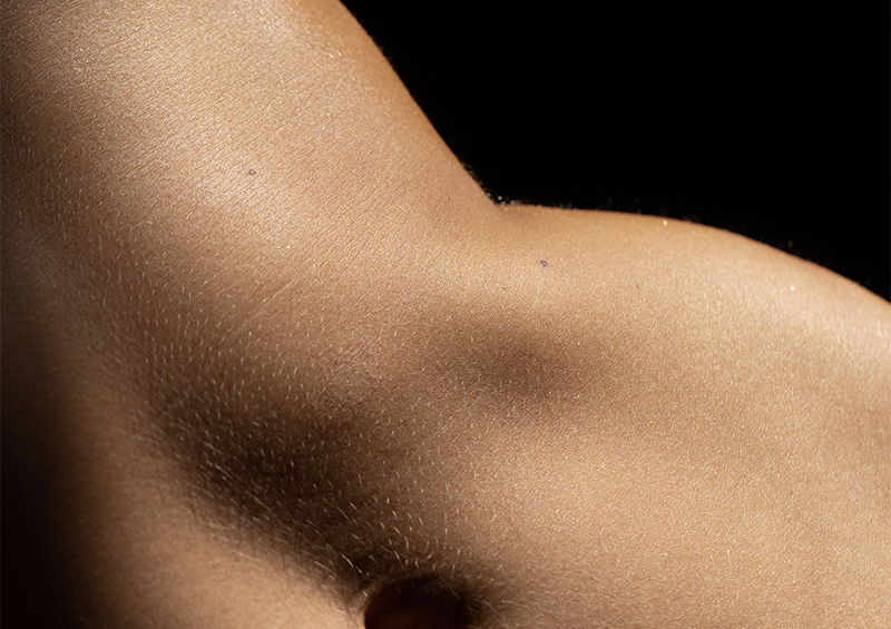 esfoliazione: corpo femminile nudo su sfondo scuro